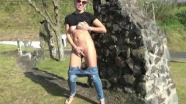 Blonde shows off her naked body and masturbates on a busy street.